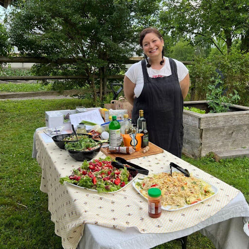 woman-smiling-next-to-salad-table